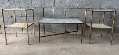 trois chaises et une table devant un mur en béton