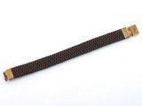 un bracelet de montre noir et doré avec un fermoir doré