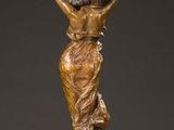 a bronze statue of a woman carrying a pot on her head