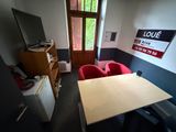 an image of a room with a table and red chairs