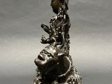 a statue of a woman sitting on top of a rock