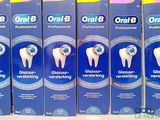 several boxes of toothpaste sitting on a shelf in a store