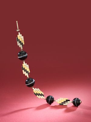a black and yellow beaded necklace on a red surface