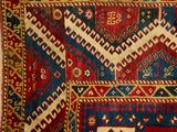 a close up of a red, blue, and green rug with geometric designs