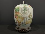 un vase blanc avec un tableau sur une table