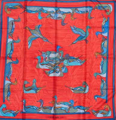 foulard en soie rouge orné d'oiseaux bleus et orange sur fond rouge