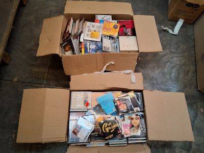 une boîte en carton remplie de livres et de magazines posée par terre