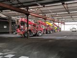 de nombreux camions rouges et jaunes garés dans un garage