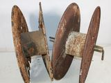 two old rusty reels are sitting on a white surface