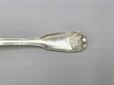 silver spoon with a flower design on it sitting on a table
