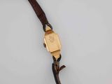 a close up of a wrist watch with a brown leather strap