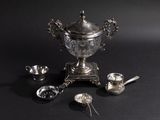 a silver cup with spoons and spoons next to it