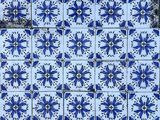a close up of a blue and white tiled wall with a window