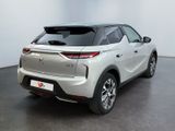 the rear end of a silver suv parked in a white room