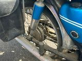 une moto bleue garée sur le bord de la route