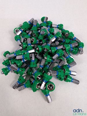 un tas de Lego verts posé sur une surface blanche