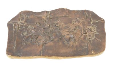 a stone plaque with a design on it on a white surface