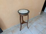 une petite table au plateau en marbre, dans un coin de la pièce