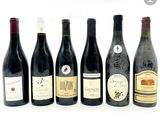 plusieurs bouteilles de vin sont alignées sur une surface blanche