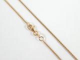 a close up of a gold chain on a white background