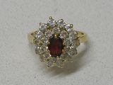 gros plan d'une bague avec une pierre rouge entourée de diamants blancs