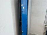 a blue locker next to a radiator in the corner of a room