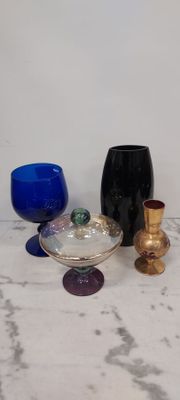 de nombreux objets en verre de différentes couleurs posés sur une table