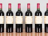 six bouteilles de vin rouge alignées sur une table en bois