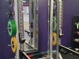 une salle de sport équipée d'un support pour haltères et d'appareils de musculation