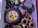 de nombreux vases de toutes sortes dans une boîte violette posée par terre