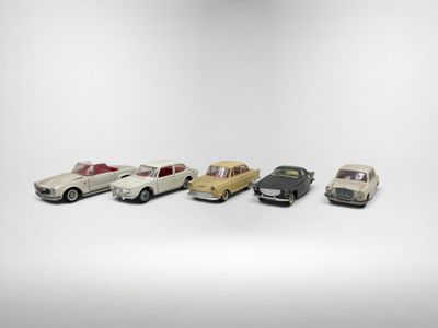 un groupe de petites voitures posées sur une surface blanche