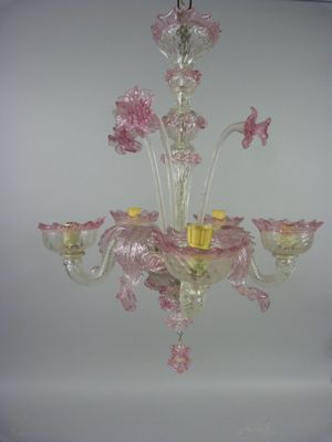 un lustre en verre d'où pendent des fleurs roses