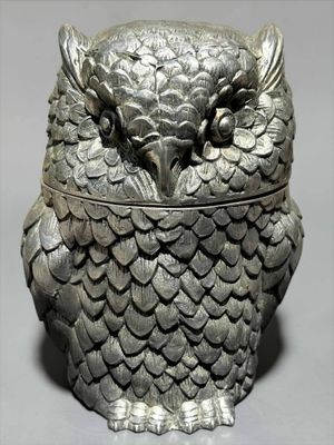 une boîte en forme de chouette, avec une grande tête et des ailes dessus