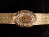 an image of a close up of a gold wrist watch with diamonds