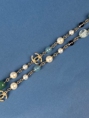 necklace with pearls and green glass beads on a blue background