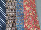 four different colored ties hanging on a wall in a room