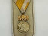 une image représentant une médaille dans un écrin posé sur une surface blanche