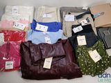 beaucoup de vêtements et un sac à main sur la table