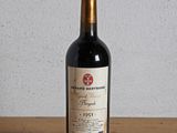 une bouteille de vin rouge posée sur une table en bois