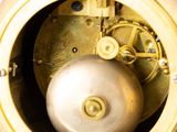 a close up of a gold clock with a white face