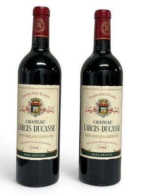 two bottles of red wine sitting next to each other on a white surface