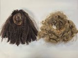 two wigs that are on a white surface