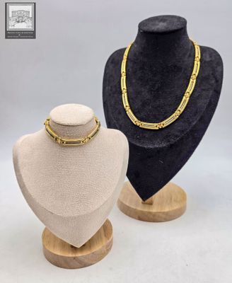deux mannequins et un collier exposés dans une vitrine