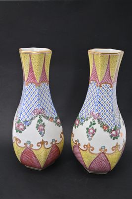 une paire de vases posés sur une surface noire, sur fond noir