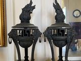 two black vases sitting on a table in a room