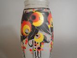 a vase with a painting on it sitting on a table