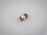 gros plan d'une bague en or sur une surface blanche