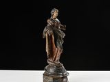 an antique bronze statue of a woman holding a child