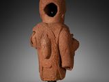 an ancient statue of a man with a hat on his head