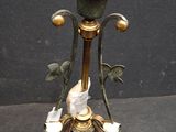 a metal candle holder with a bird on top of it